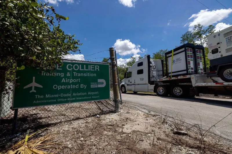 إشارة إلى مطار كولير، حيث يتم نقل معدات، تعكس جهود إدارة ترامب في ترحيل المهاجرين من دول مثل كوبا وفنزويلا.