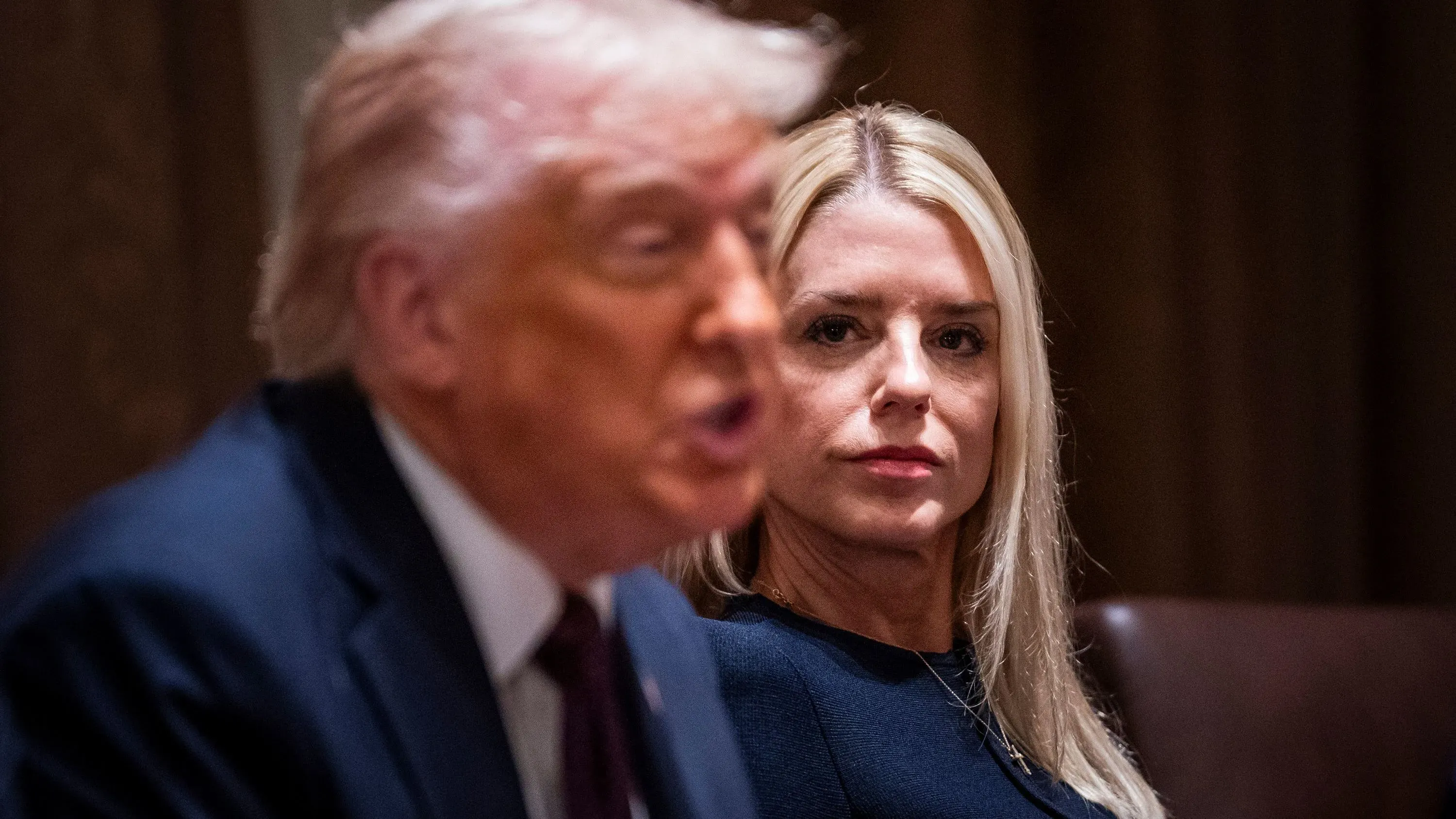 اجتماع رسمي يظهر الرئيس السابق دونالد ترامب يتحدث بينما تتابعه المدعية العامة بام بوندي، في سياق مناقشات حول التحقيقات الجنائية.