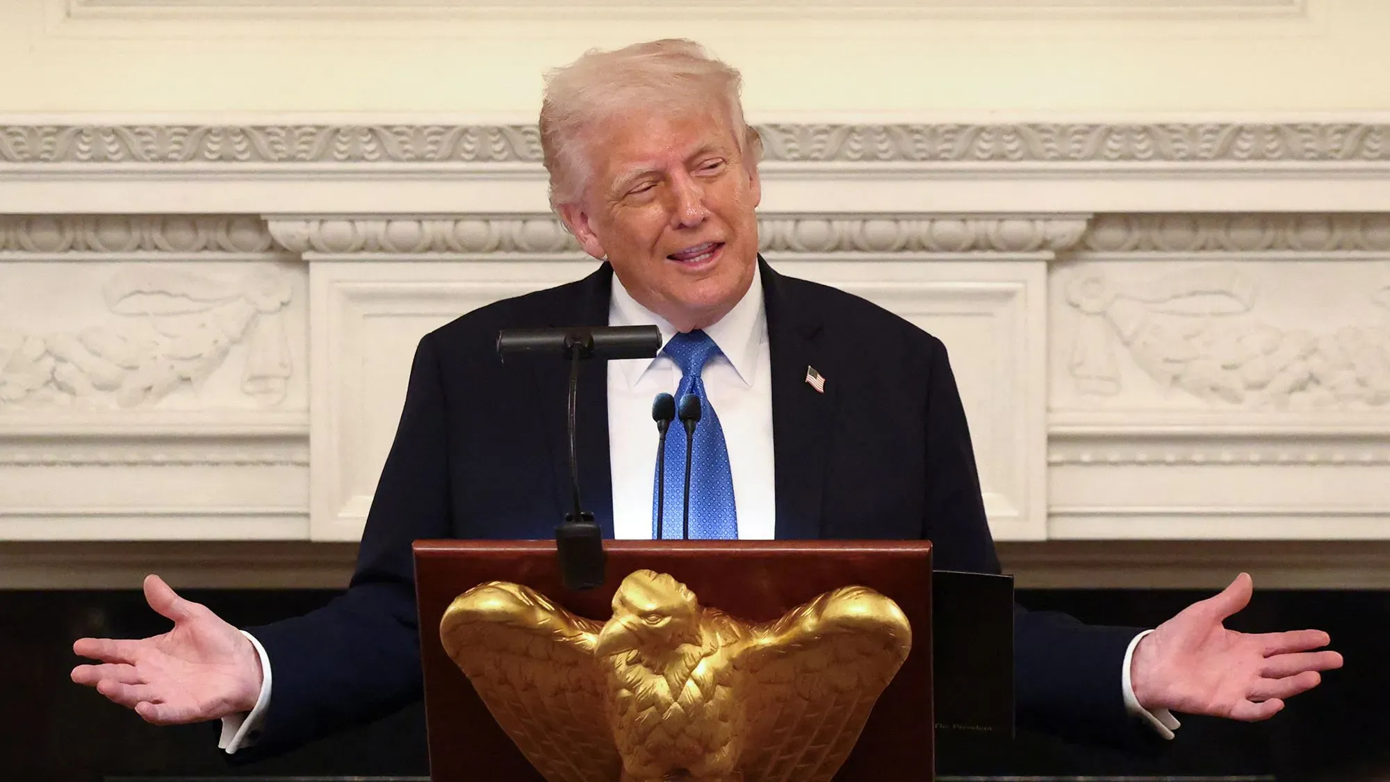 ترامب يتحدث في مؤتمر صحفي، مع تعبيرات وجهية توضح حماسه، بينما يتناول قضايا الميزانية والتخفيضات الضريبية.