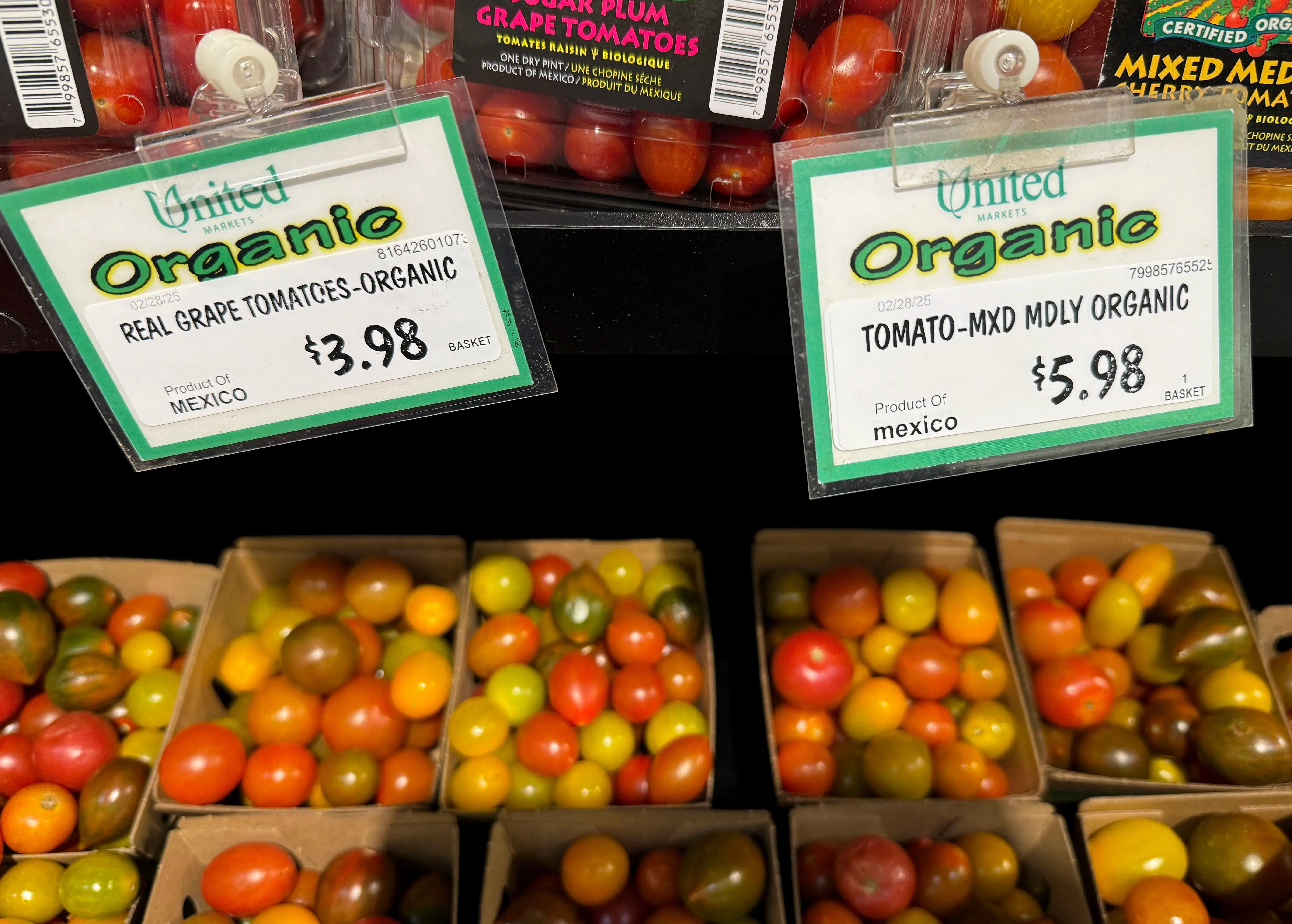 أسعار الطماطم العضوية المستوردة من المكسيك معروضة في متجر، مع تفاصيل الأسعار لكل نوع. تعكس الصورة تأثير التعريفات الجمركية.