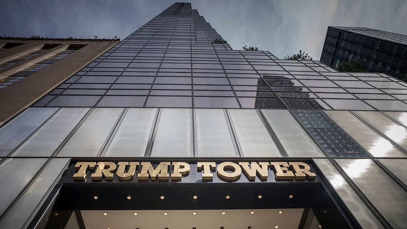 واجهة برج ترامب في نيويورك، مع لافتة تحمل الاسم، تعكس الجدل حول إغلاق حسابات ترامب المصرفية بسبب الآراء السياسية.