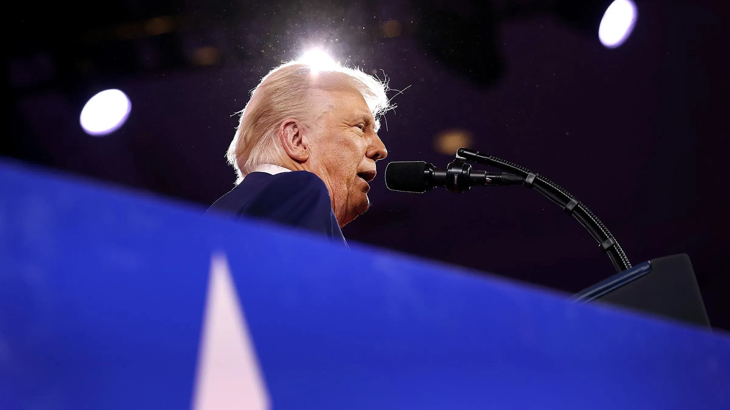 ترامب يتحدث من خلف منصة، مع إضاءة خلفية، مشيراً إلى تأثيره على الانتخابات المقبلة ودعمه لمرشحي الحزب الجمهوري.