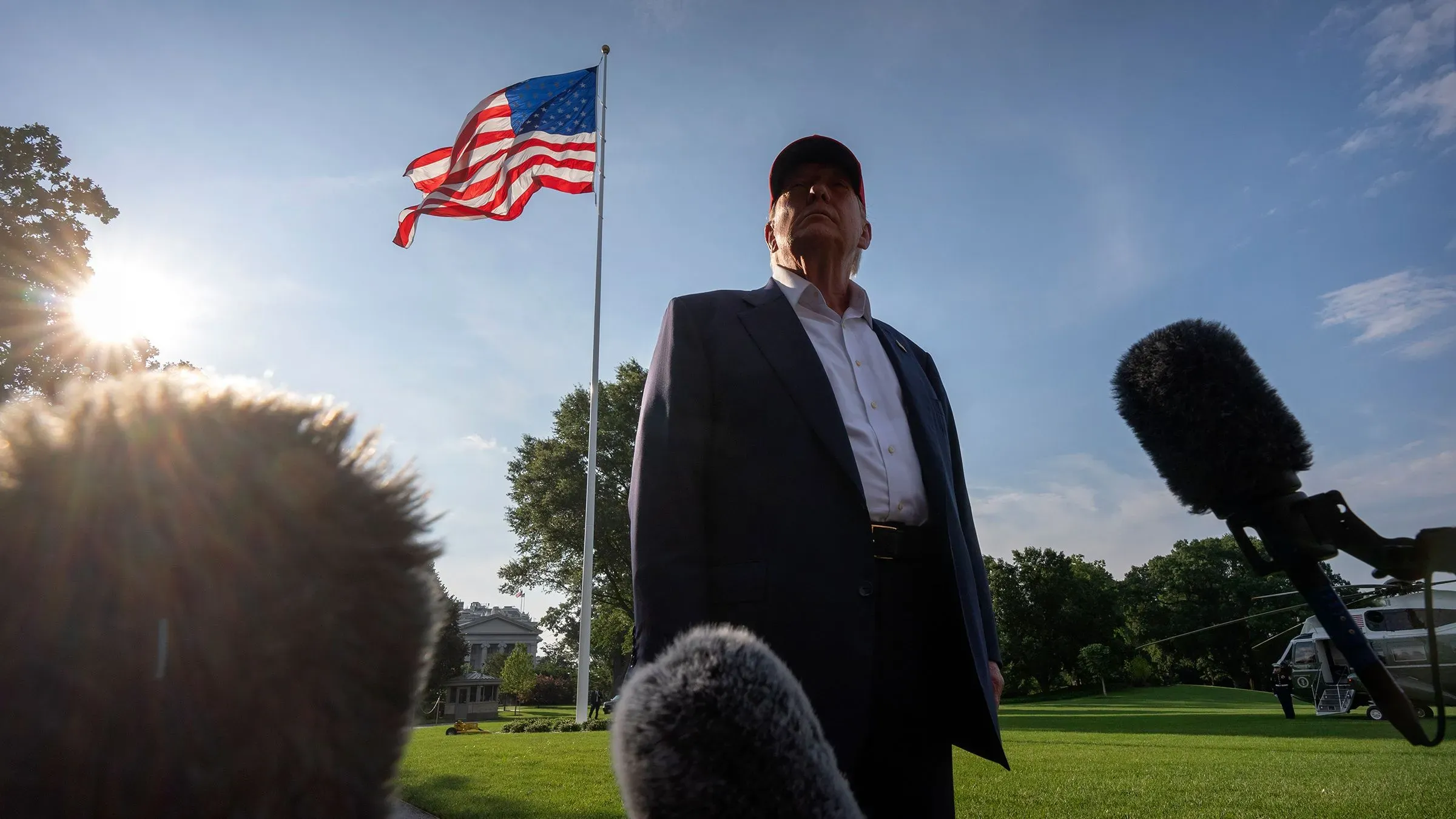 ترامب يقف أمام علم الولايات المتحدة في الحديقة الجنوبية للبيت الأبيض، مستعدًا للاحتفال بتمرير مشروع قانون ضخم.