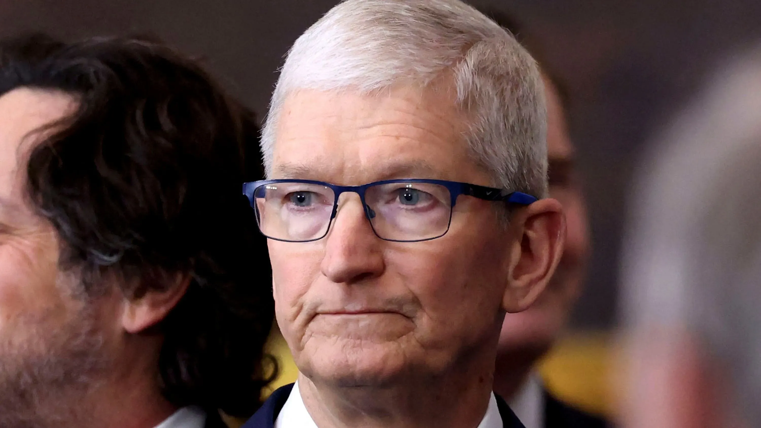 تيم كوك، الرئيس التنفيذي لشركة آبل، يظهر في حدث رسمي، مع تعبير جاد، وسط مناقشات حول خطط تصنيع آيفون في الهند.