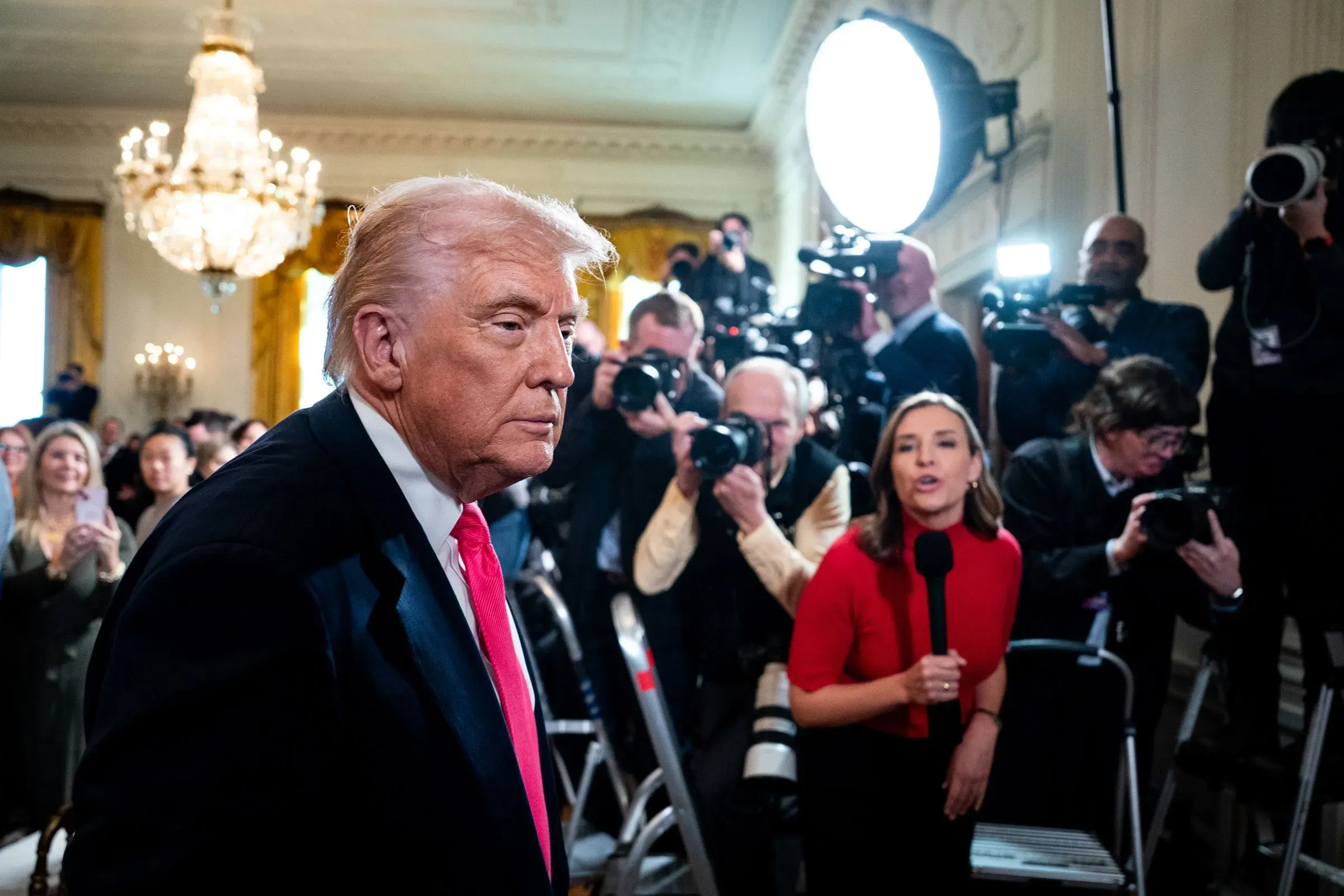 ترامب يتحدث للصحفيين وسط حشد من الكاميرات في حدث رسمي، مع تسليط الضوء على توتره بعد اعتذار بي بي سي عن فيلم وثائقي.