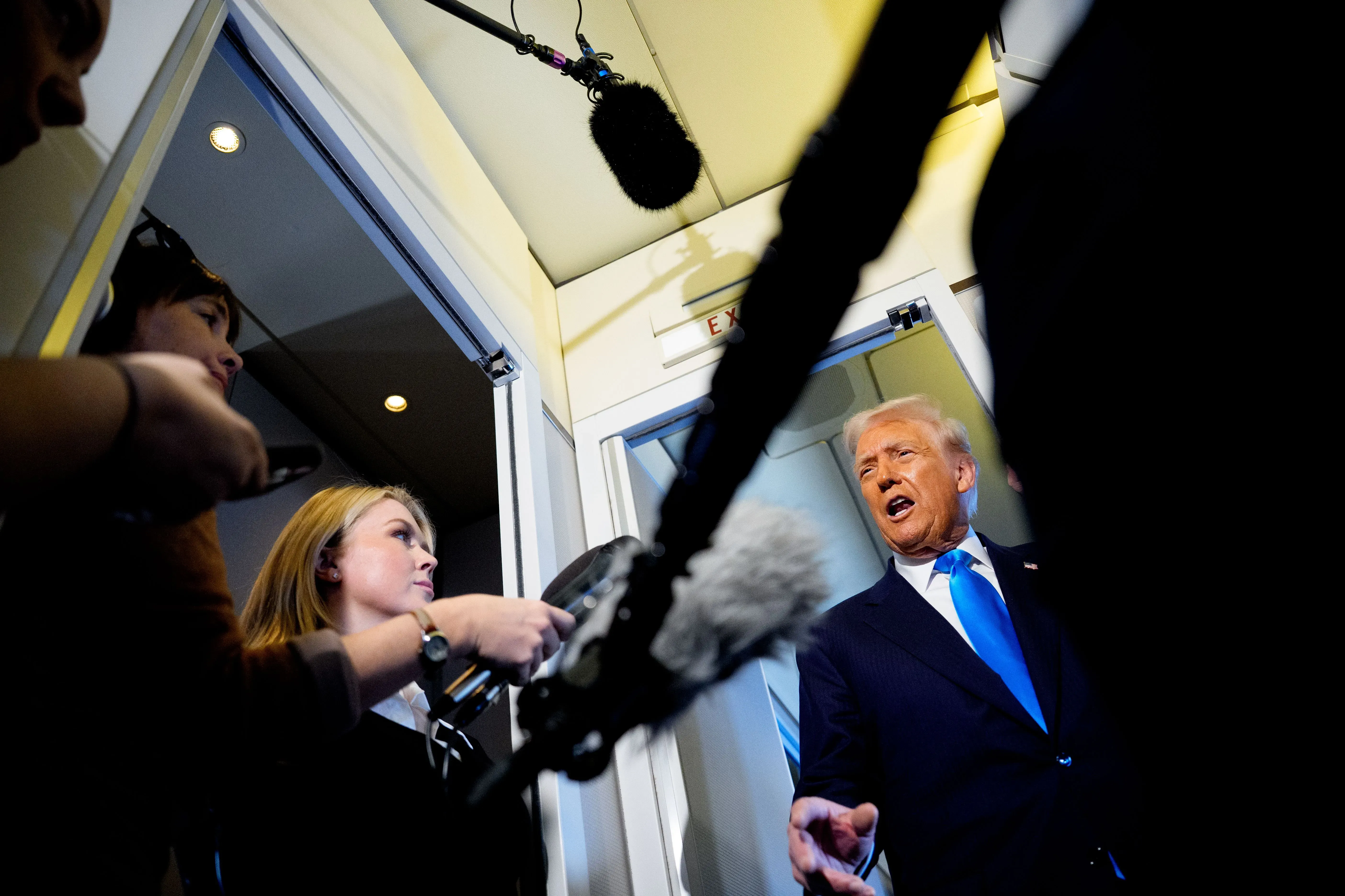 ترامب يتحدث للصحفيين على متن الطائرة الرئاسية، محاطًا بمراسلين، مع التركيز على تصريحاته حول ترشحه المحتمل لولاية ثالثة.