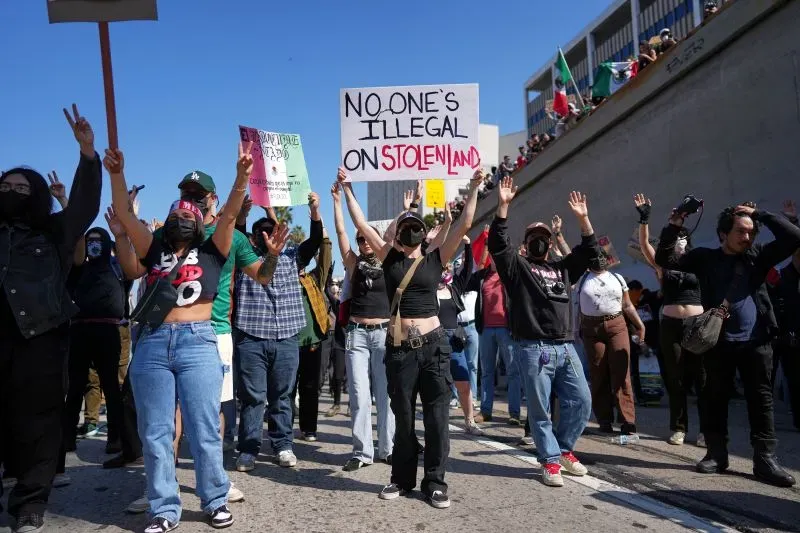 محتجون في لوس أنجلوس يرفعون لافتات معبرة عن حقوق المهاجرين، خلال مظاهرة ضد مداهمات الهجرة الفيدرالية.