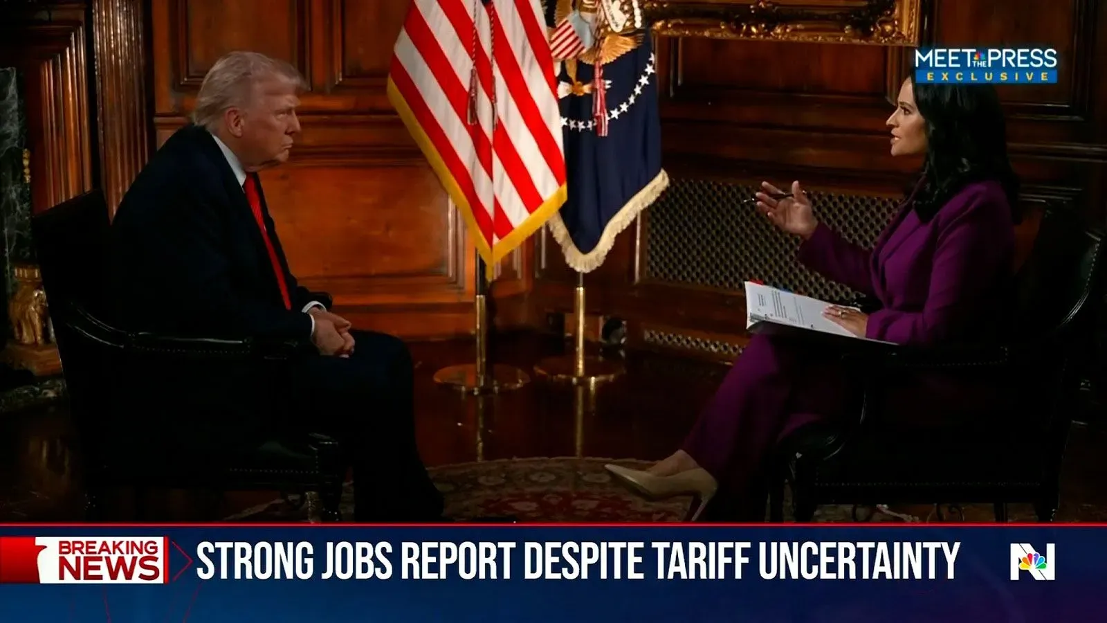 ترامب يتحدث مع صحفية في مقابلة حول الاقتصاد الأمريكي، مع العلم بأن العلم الأمريكي خلفهما، وسط توترات حول التعريفات الجمركية.