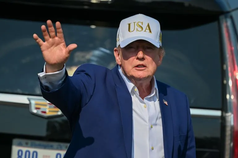 الرئيس الأمريكي السابق دونالد ترامب يلوح بيده مرتديًا قبعة تحمل شعار "USA" في سياق حديثه عن الضغط الاقتصادي على إيران والمفاوضات.