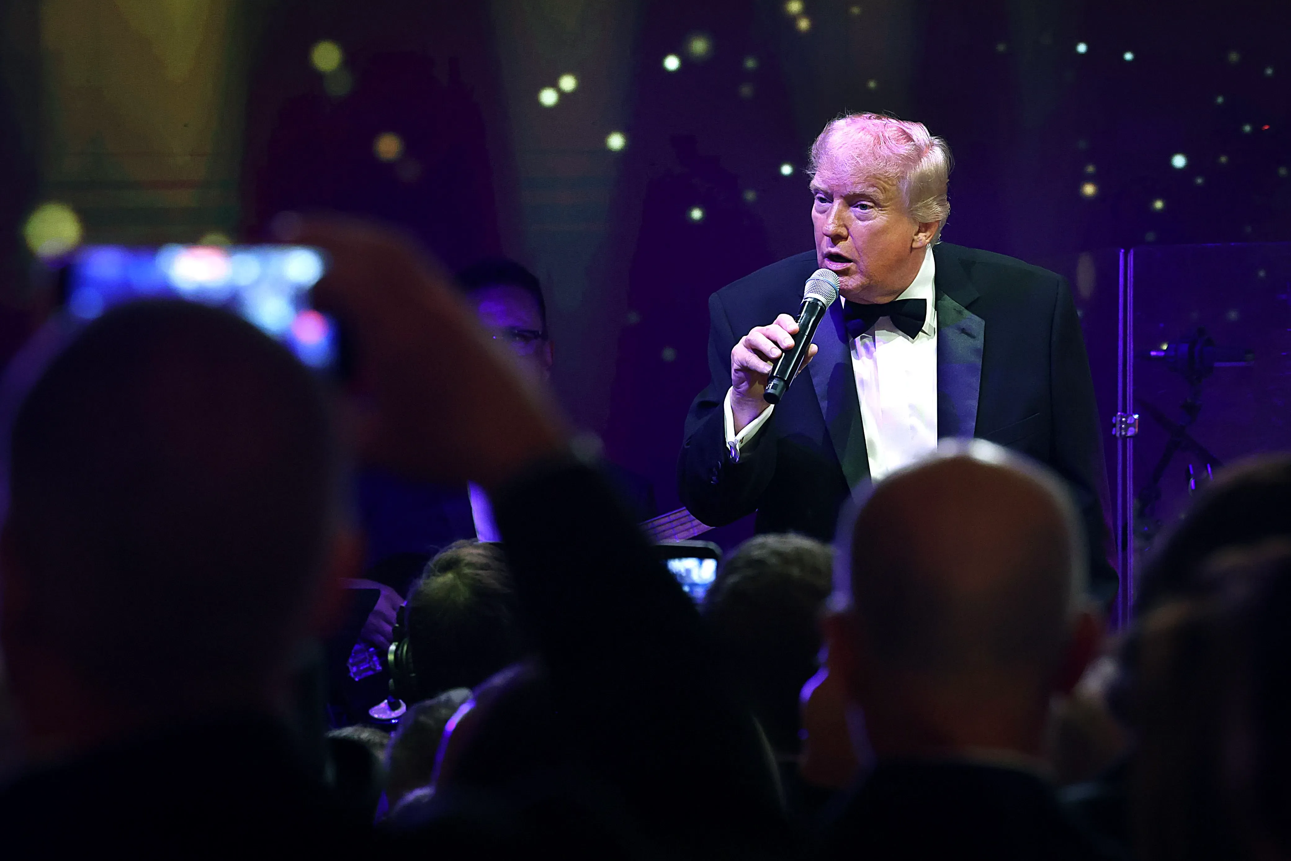 ترامب يتحدث إلى الجمهور خلال حدث رسمي، مع التركيز على صحته وجرعة الأسبرين التي يتناولها، وسط تفاعل الحضور.