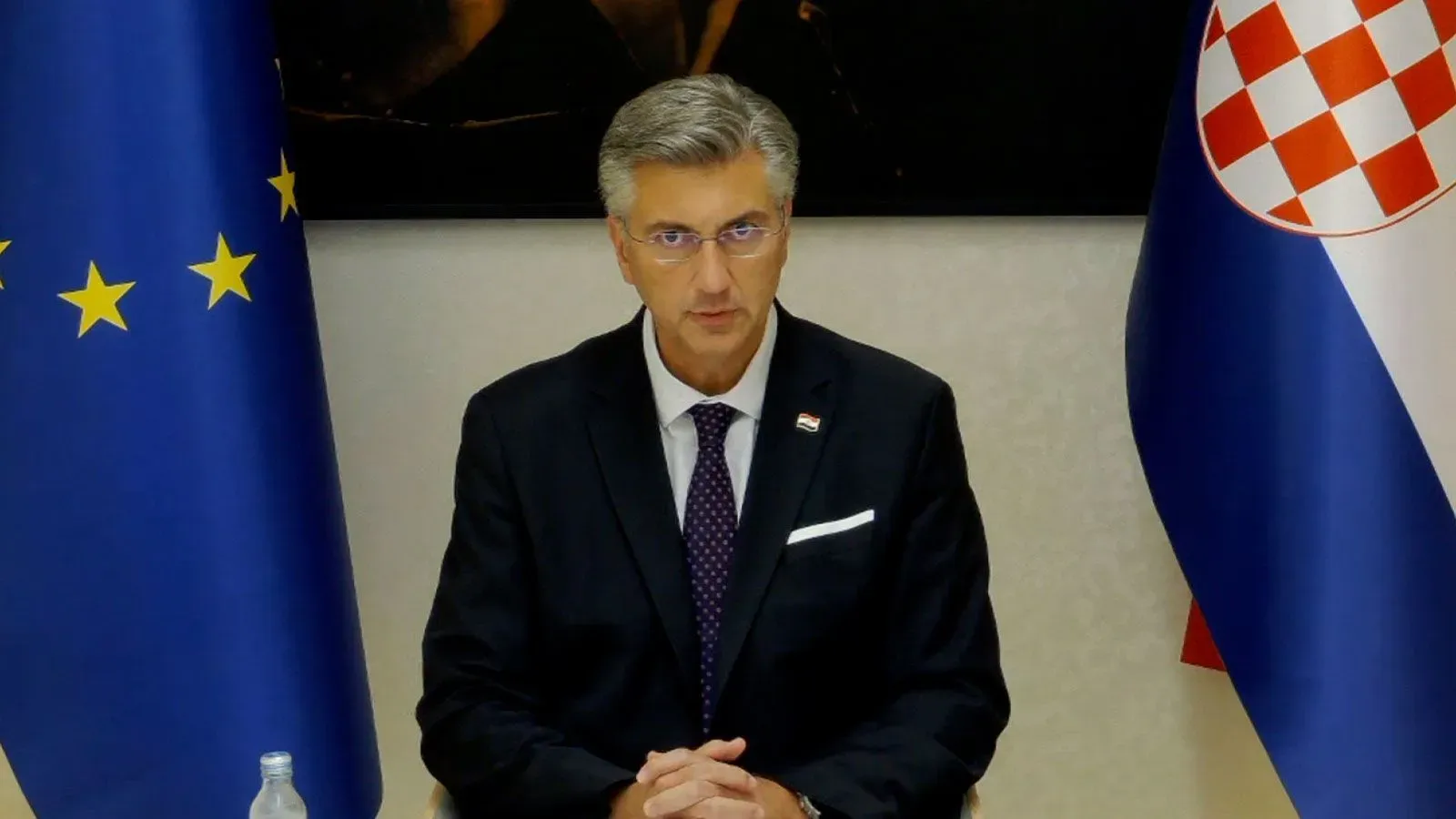 رئيس وزراء كرواتيا، أندريه بلينكوفيتش، يجلس أمام علم الاتحاد الأوروبي وعلم كرواتيا، يتحدث في مؤتمر صحفي حول السياسة الخارجية.