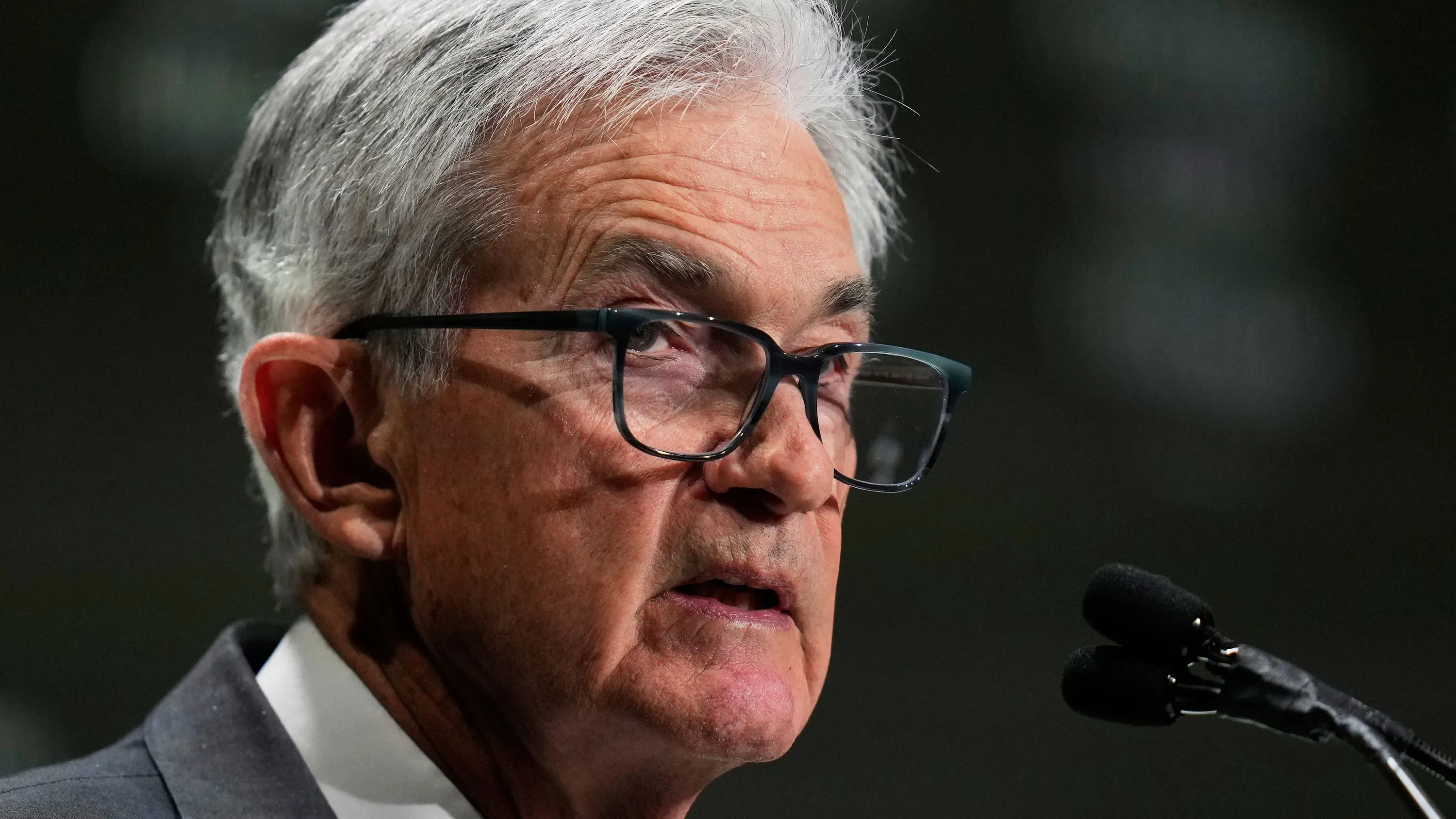 جيروم باول، رئيس الاحتياطي الفيدرالي، يتحدث خلال مؤتمر، مع تعبيرات جادة تعكس التوترات الاقتصادية الحالية.