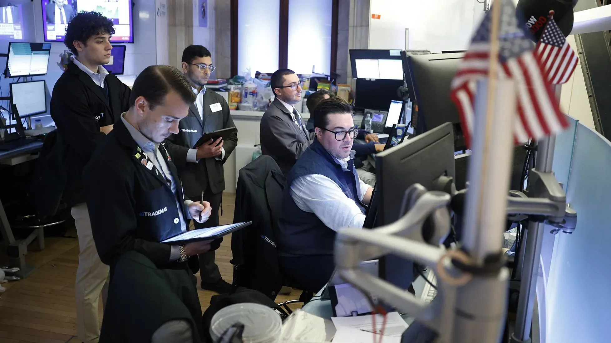 مجموعة من المتداولين في غرفة التداول يراقبون الشاشات خلال مزاد سندات الخزانة الأمريكية لأجل 30 عامًا، مع التركيز على السوق المالية.