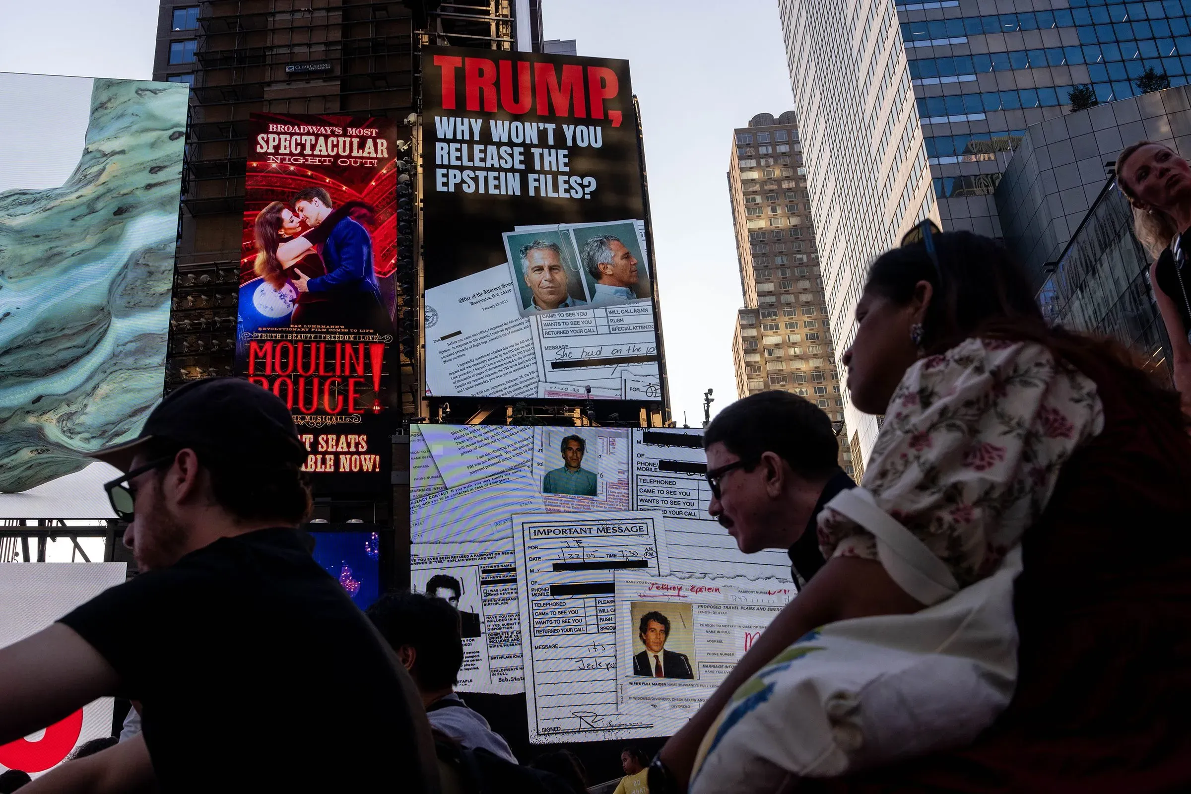 لافتة في تايمز سكوير تتضمن صورة لجيفري إبشتاين، مع نص يتساءل عن سبب عدم إفراج ترامب عن ملفات إبشتاين، بينما يتجمع الناس حولها.