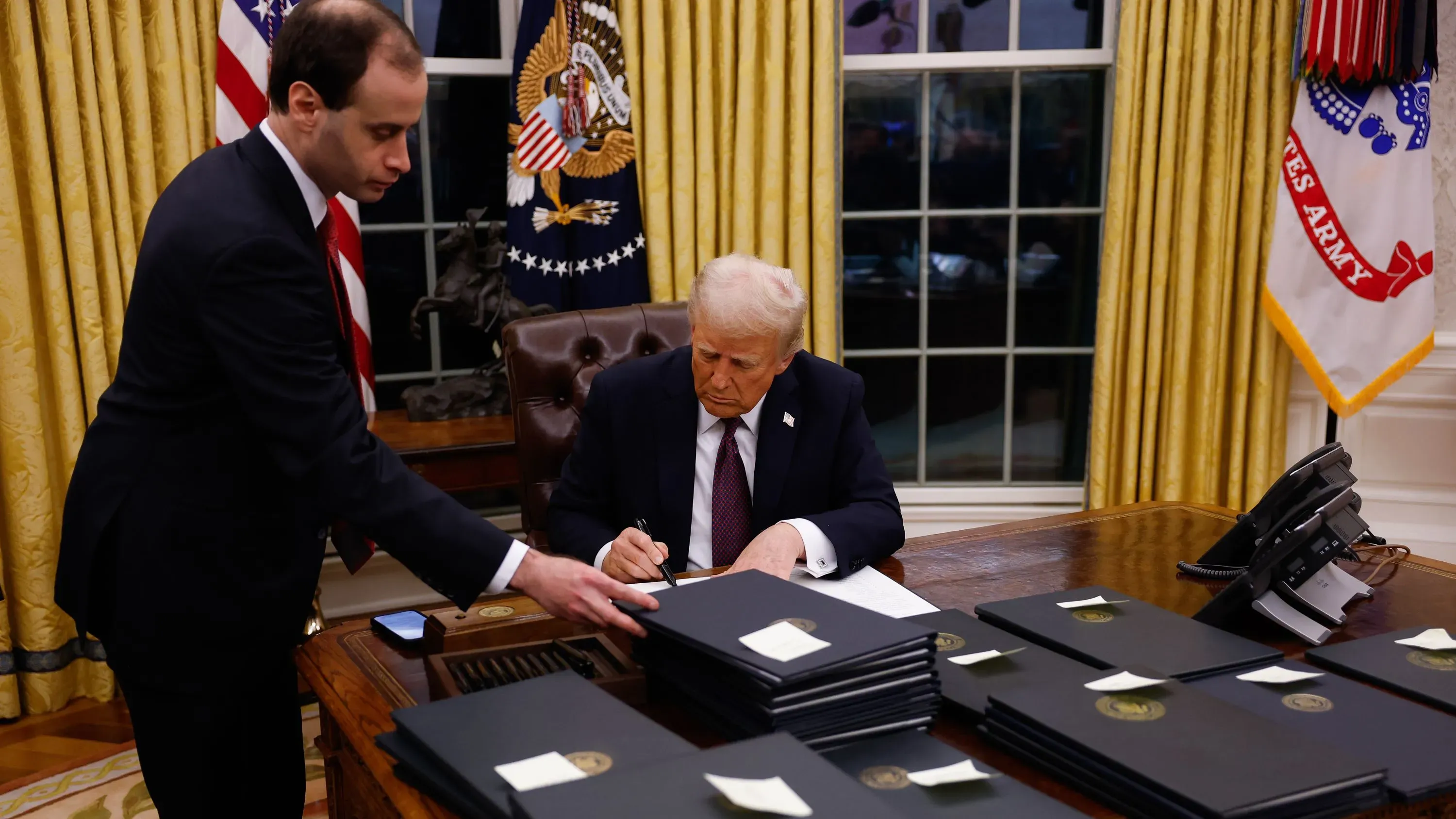 ترامب يوقع أوامر تنفيذية في المكتب البيضاوي مع موظف، ويستهدف إنهاء برامج التنوع والمساواة والتعديلات البيئية.