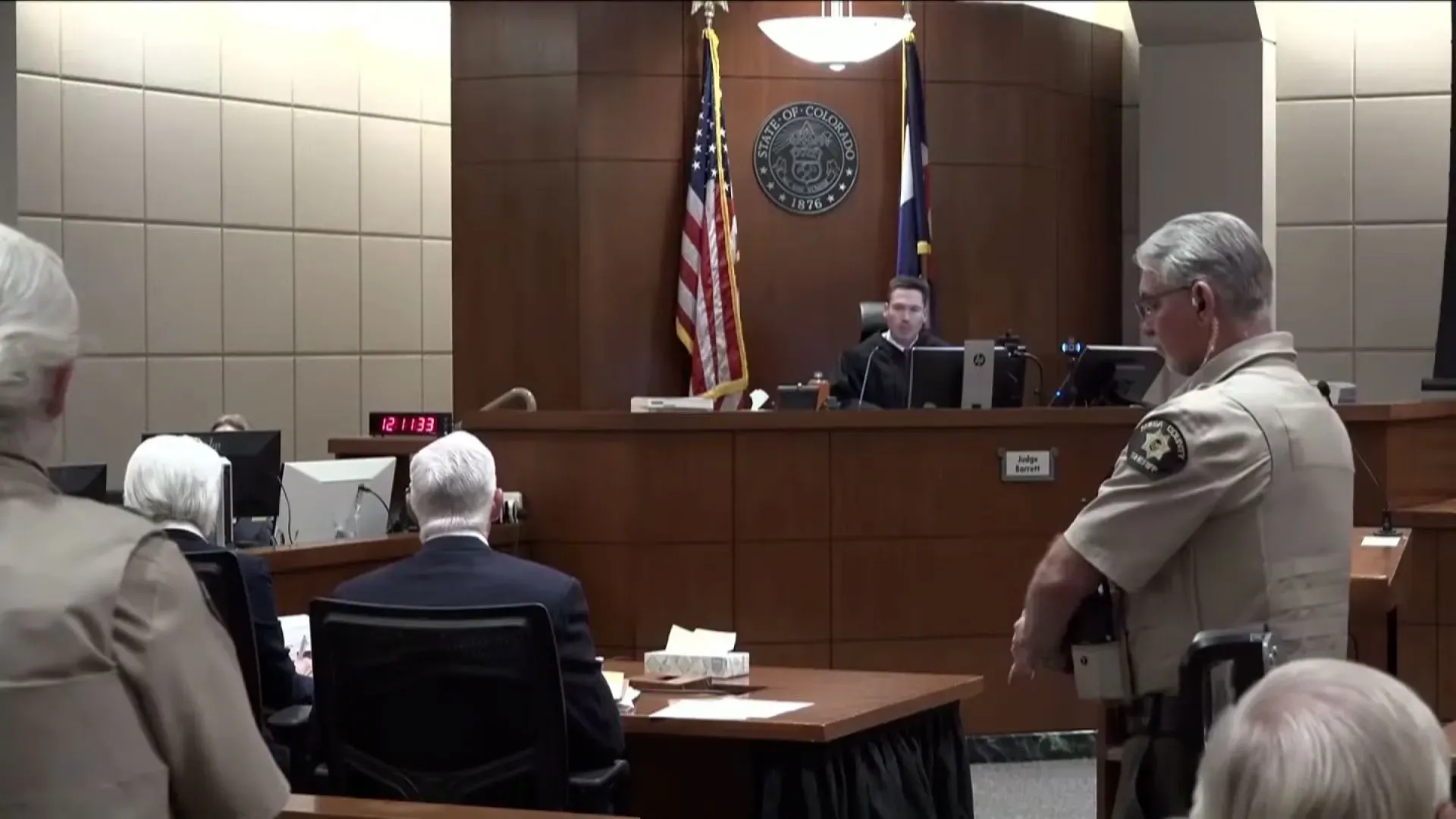 جلسة محكمة في كولورادو، حيث يظهر القاضي متحدثًا مع محامين ومراقبين، في سياق قضية تينا بيترز المتعلقة بالتلاعب بآلات التصويت.