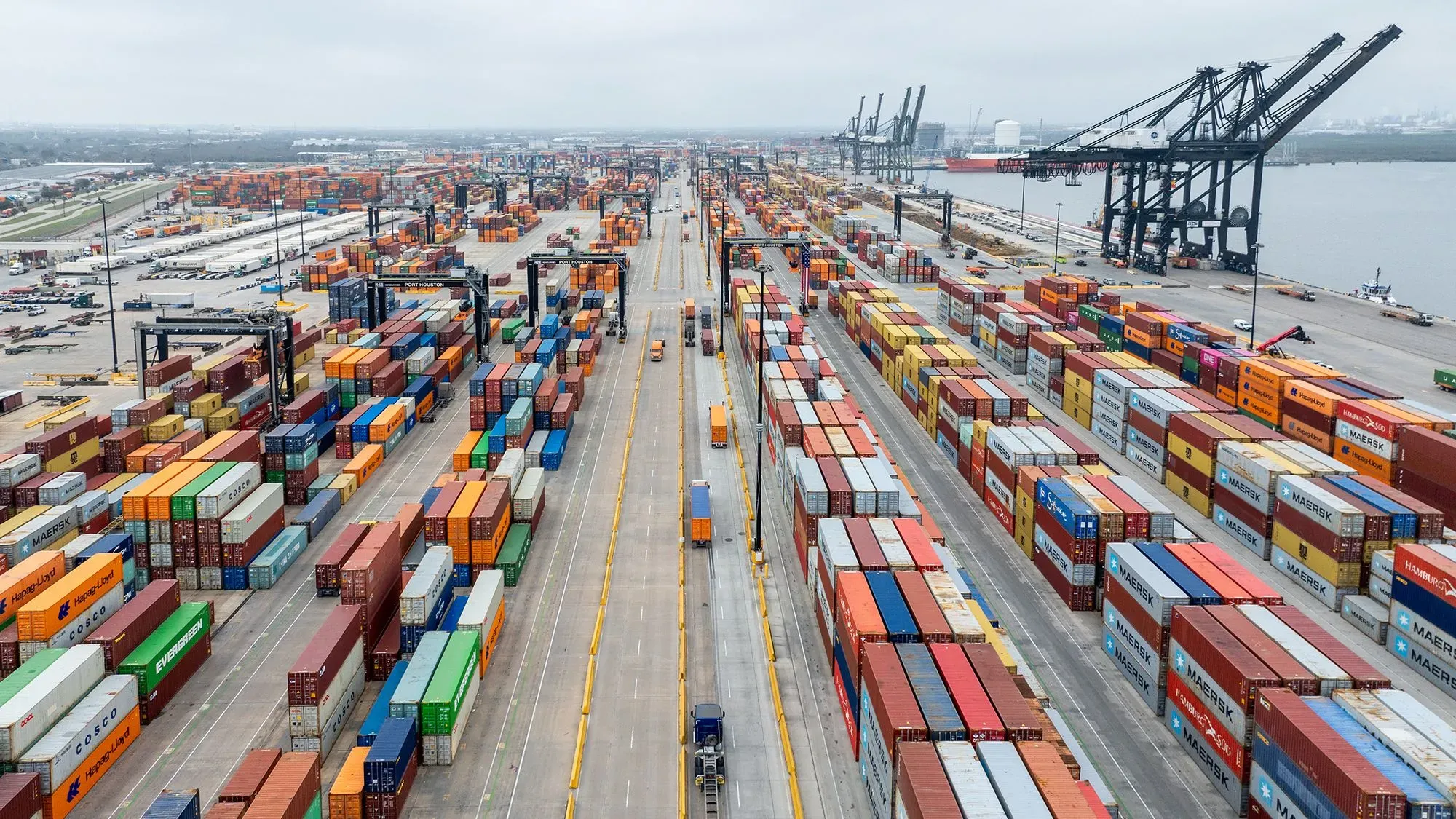 صورة لميناء مزدحم يحتوي على حاويات شحن ملونة، تعكس نشاط التجارة الدولية وتأثير الرسوم الجمركية المقترحة.