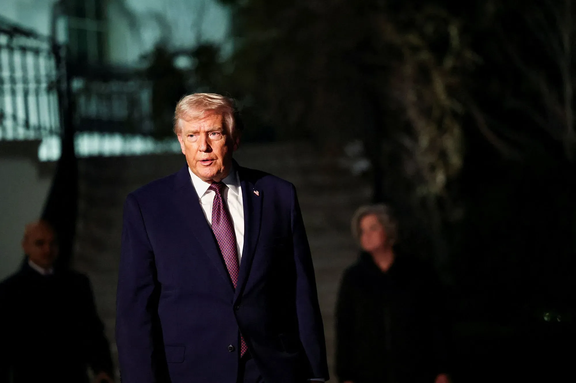 ترامب يسير خارج البيت الأبيض، مع التركيز على تعبير وجهه الجاد، في إطار حديثه عن سوق العمل ومعدل البطالة.