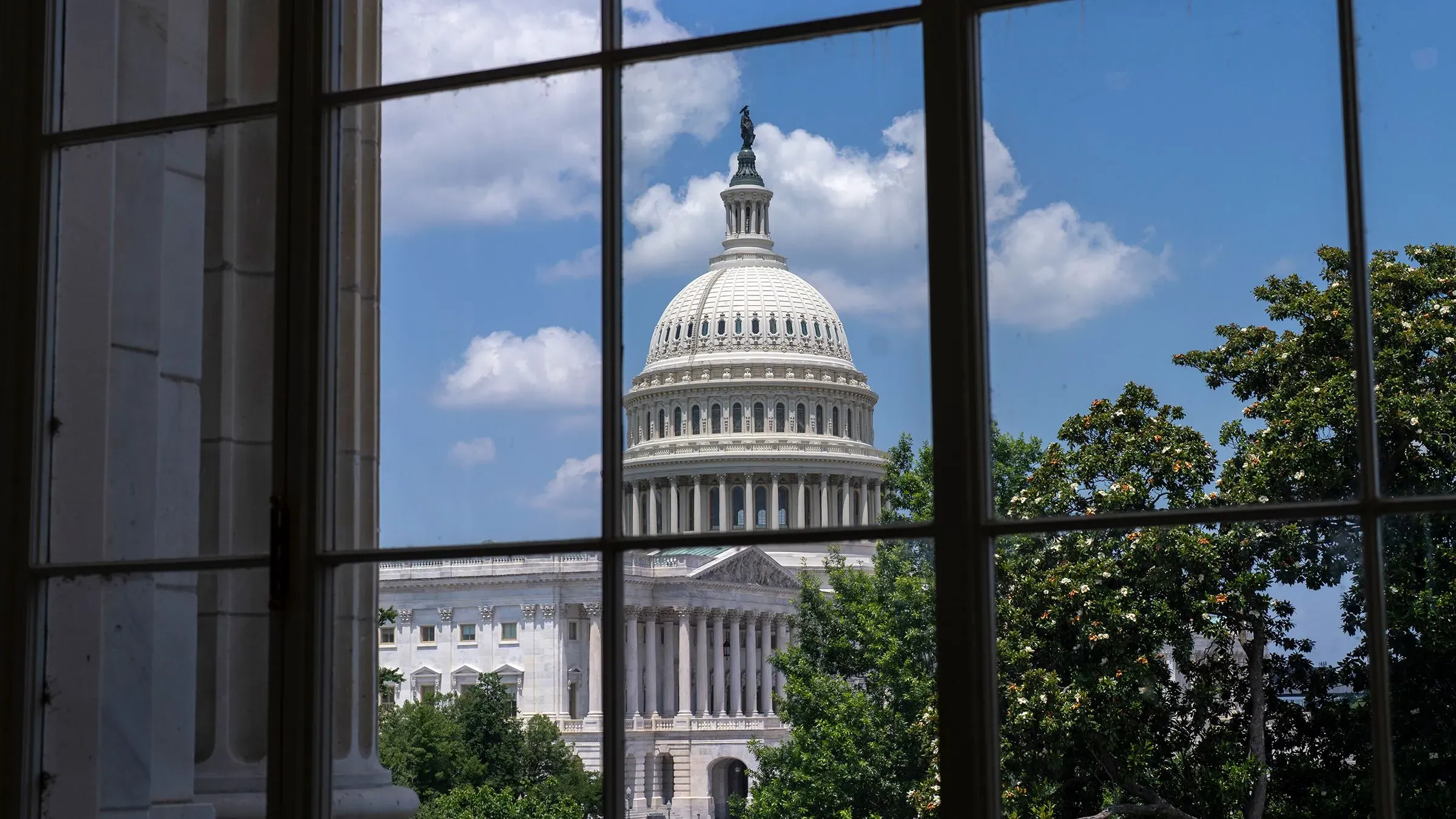 منظر لواجهة مبنى الكابيتول الأمريكي، يظهر القبة تحت سماء زرقاء مع سحب بيضاء، مما يعكس النشاط السياسي في واشنطن.