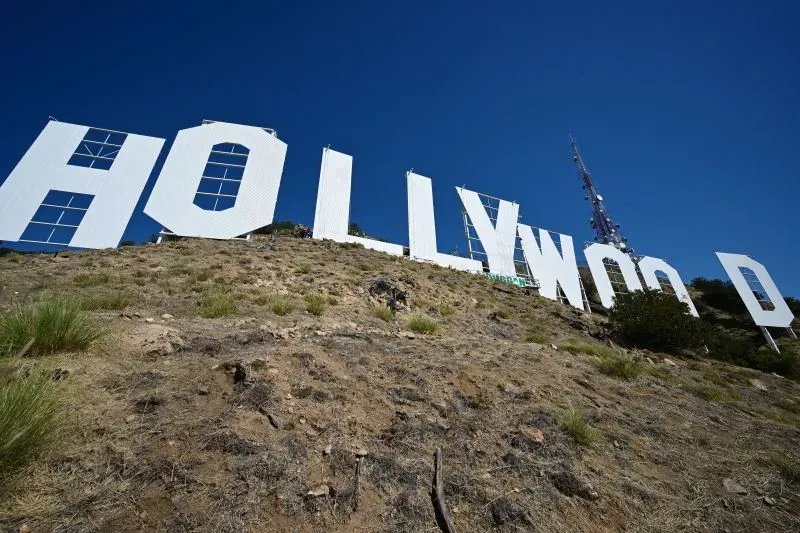 علامة هوليوود الشهيرة على تل، مع وجود بعض الأعمال الإنشائية، تمثل صناعة السينما الأمريكية التي تواجه تحديات اقتصادية.