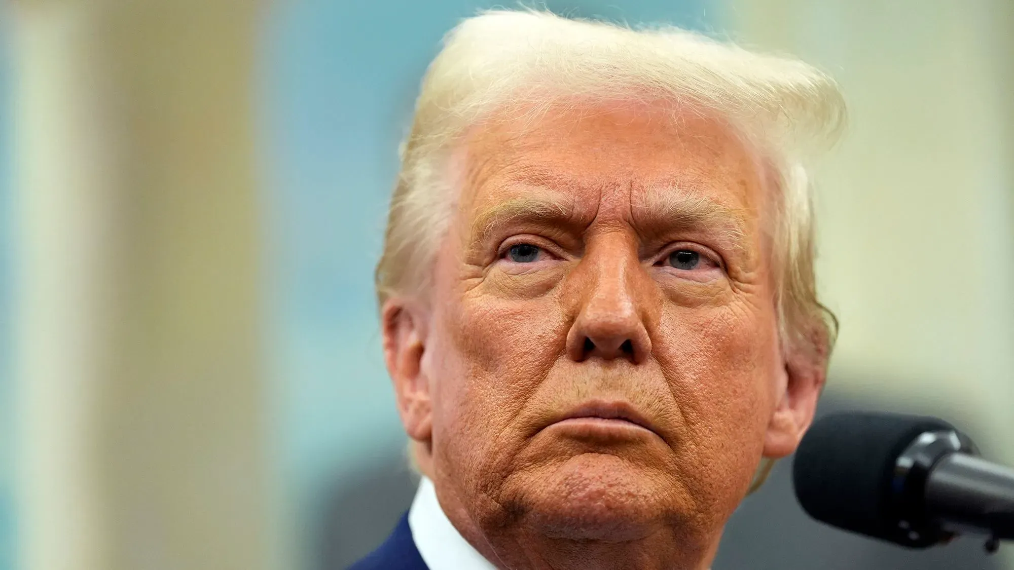 صورة لدونالد ترامب خلال مؤتمر صحفي، حيث يظهر تعبيره الجاد، مما يعكس التوترات السياسية المتعلقة بالحرب في أوكرانيا.