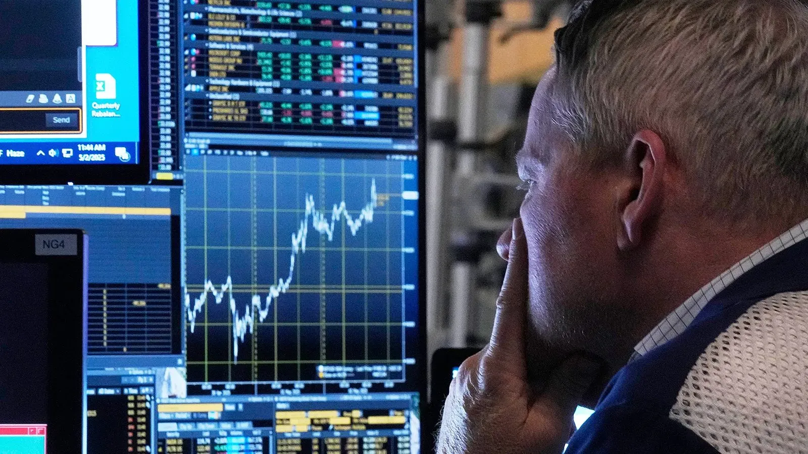 تظهر الصورة متداولًا يراقب شاشات تعرض بيانات السوق المالية، مع تزايد التقلبات في العملات والأسواق العالمية.