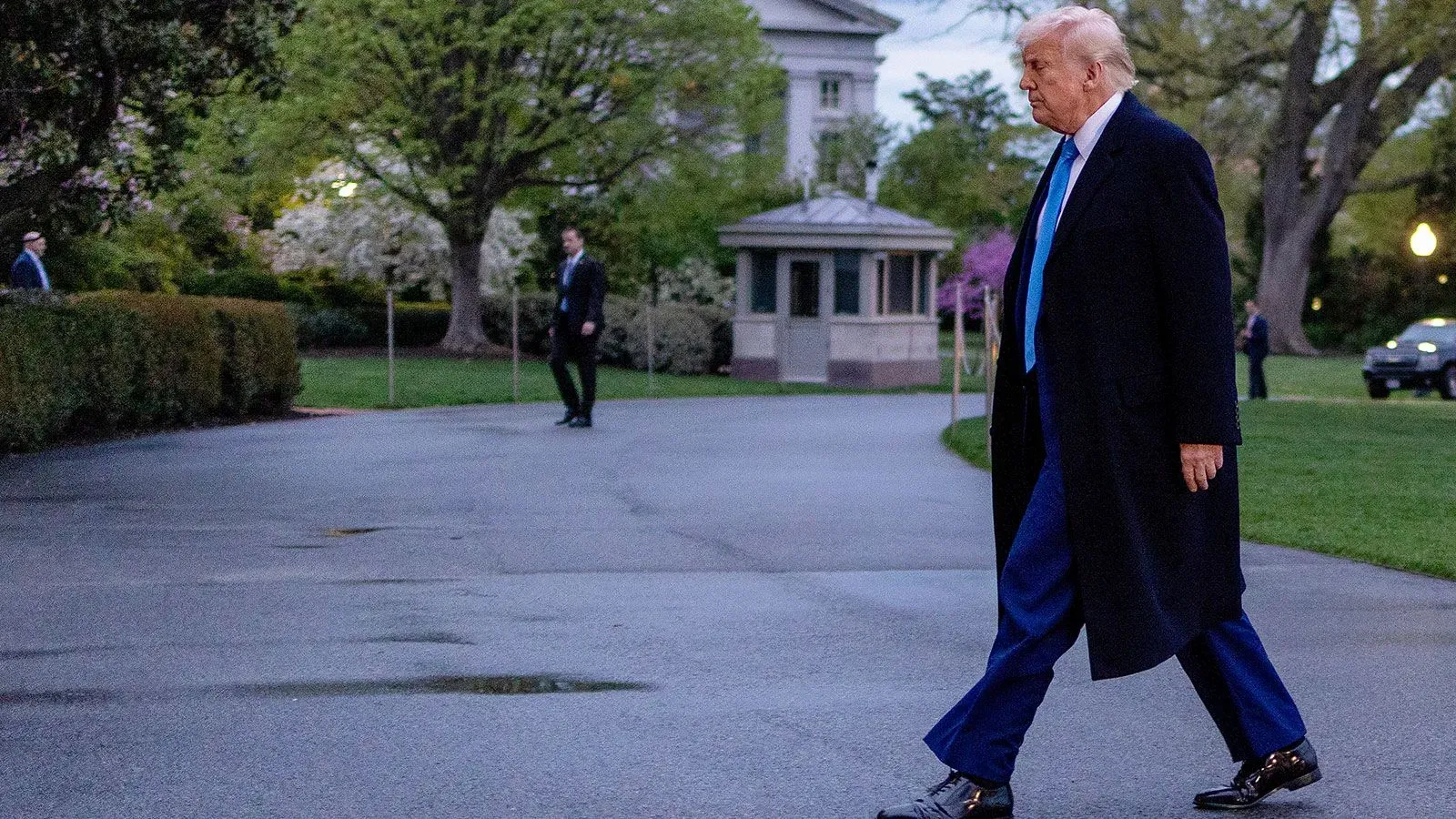 ترامب يسير في حديقة البيت الأبيض، مع ظهور بعض الموظفين في الخلفية، في وقت يشهد فيه السوق حالة من عدم اليقين بشأن التجارة.