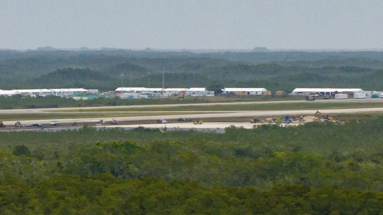 صورة لمطار في أوشوبي، فلوريدا، تُظهر منشآت مؤقتة على جانب مدرج، حيث يُخطط لاستقبال مهاجرين في معسكر "ألكاتراز التماسيح".