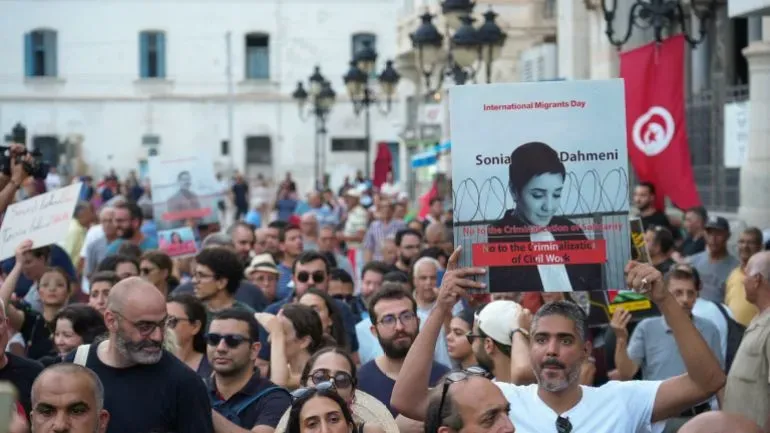 تجمع حشود من النشطاء في تونس للاحتجاج ضد الرئيس قيس سعيد، حاملين لافتات تطالب بالإفراج عن المعتقلين السياسيين، مع ترديد شعارات ضد الحكم الاستبدادي.