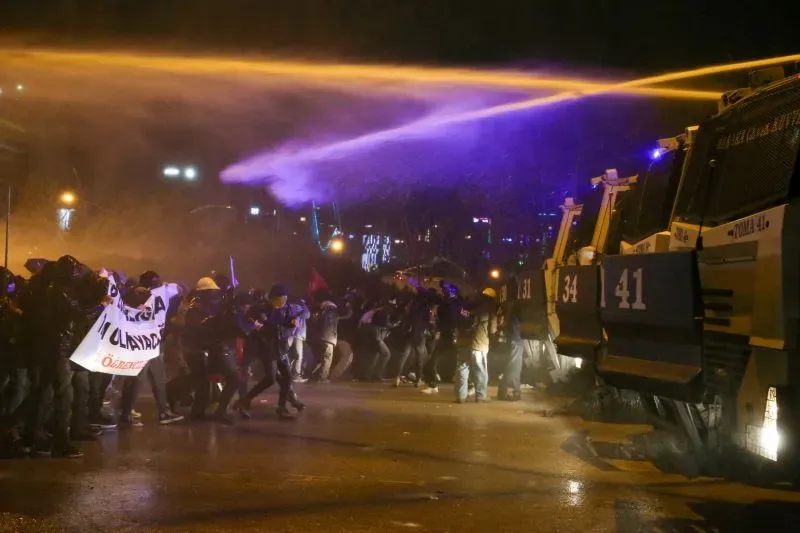 اشتباكات بين المتظاهرين وقوات الشرطة في إسطنبول، مع استخدام خراطيم المياه لتفريق المحتجين الذين يحملون لافتات.