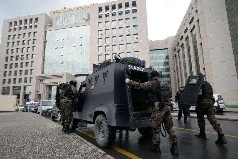 قوات الأمن التركية تنفذ مداهمات في إسطنبول، حيث يتم اعتقال مشتبه بهم في تنظيم داعش، مع وجود مركبة عسكرية في الصورة.