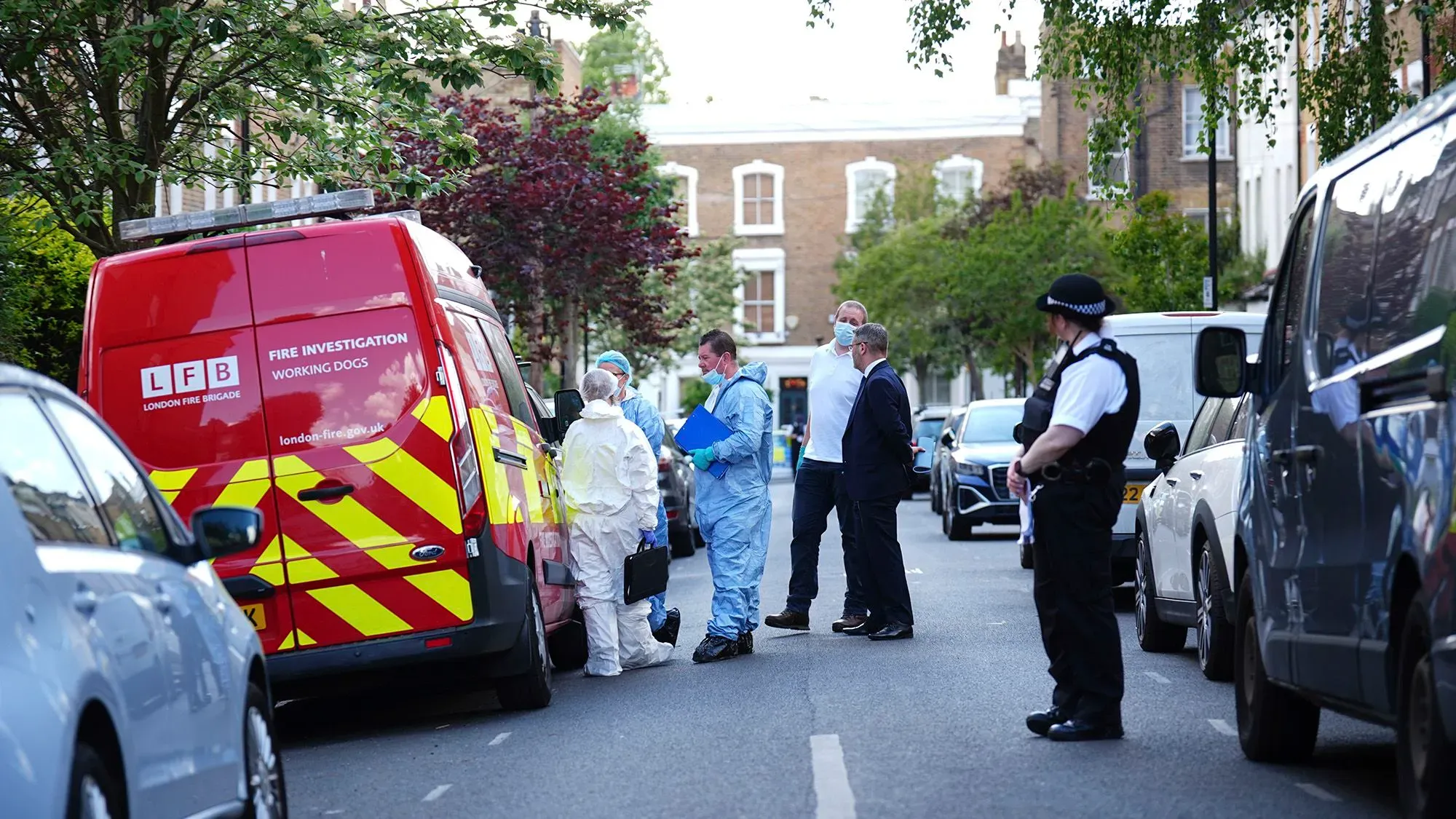 تحقيقات في حريق متعمد في شمال لندن، حيث يظهر رجال الإطفاء والشرطة في موقع الحادث مع سيارة إطفاء خلفهم.