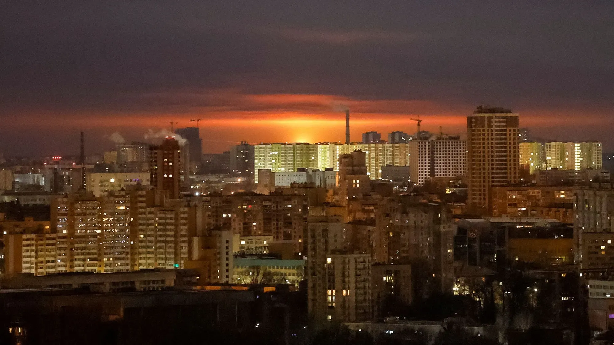غروب الشمس فوق مدينة كييف، مع ظهور الأضواء في المباني السكنية، يعكس التوترات المستمرة في الصراع الأوكراني الروسي.