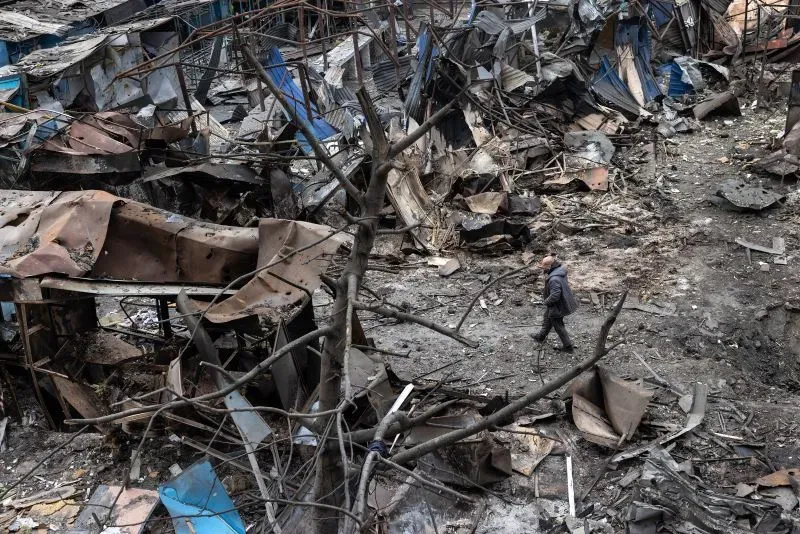 مشهد لرجال يسيرون بين الأنقاض في منطقة مدمرة، تشير إلى آثار الهجمات في بيلغورود الروسية وتأثير النزاع المستمر.