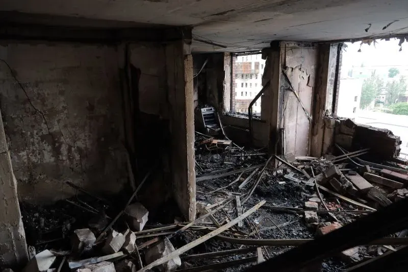 مشهد داخلي لمبنى مدمر بفعل الهجمات الروسية، يظهر الحطام والجدران المتضررة، مما يعكس آثار الصراع في أوكرانيا.