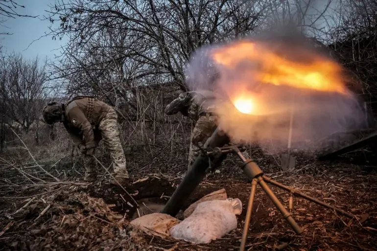 جنود أوكرانيون يستخدمون مدفع هاون خلال المعارك في منطقة زابوريجيا، مع تصاعد الدخان واللهب من الفوهة، في سياق التصعيد العسكري.