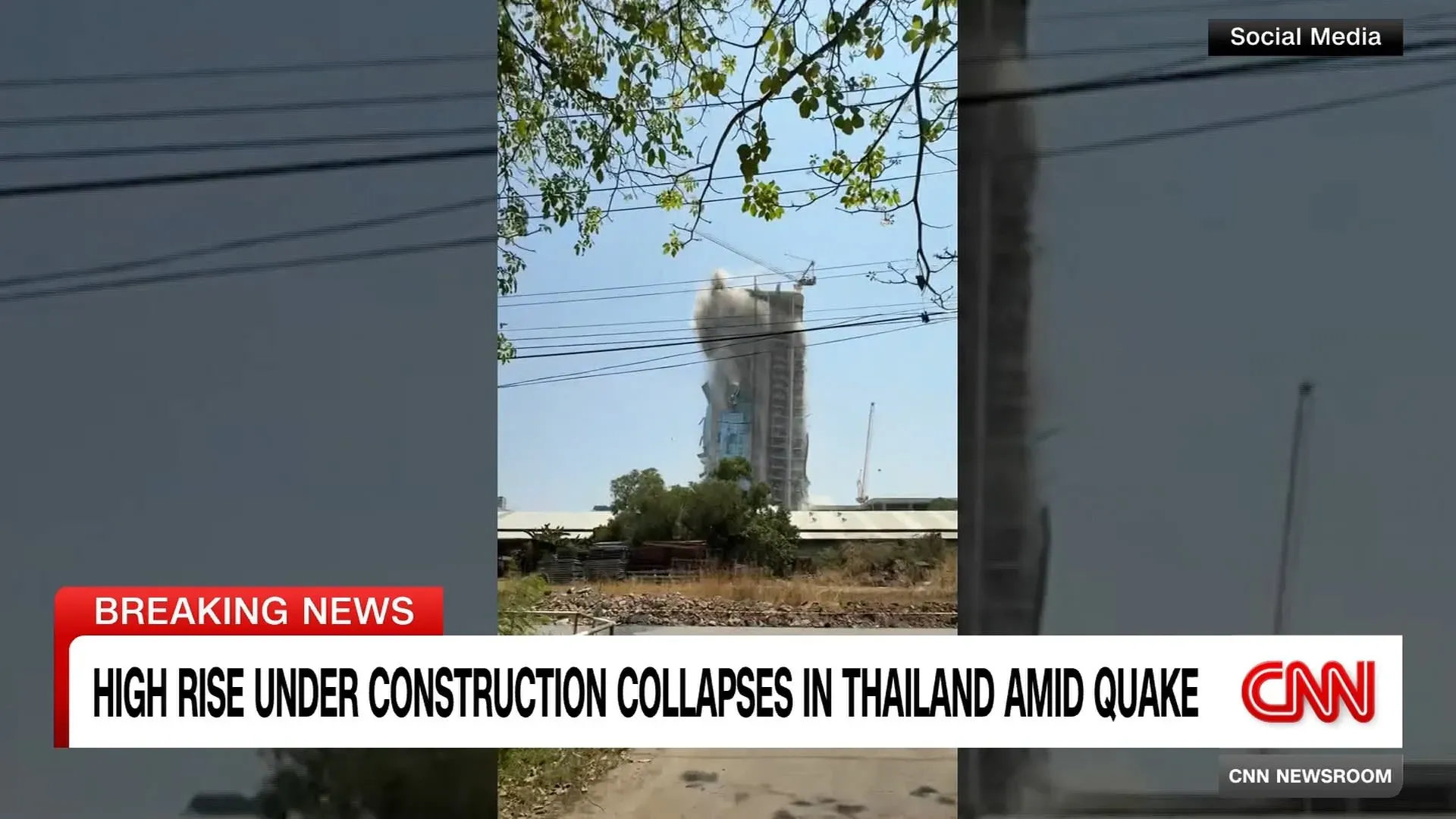 انهيار ناطحة سحاب قيد الإنشاء في بانكوك بعد زلزال قوي، مع تصاعد الغبار والدخان، وأشخاص يتجمعون في الموقع بحثًا عن المفقودين.