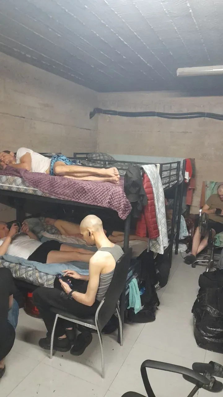 محتجزون أوكرانيون في قبو ضيق، بعضهم يستلقي على أسرّة مزدوجة، بينما يجلس آخرون في ظروف قاسية دون رعاية طبية كافية.