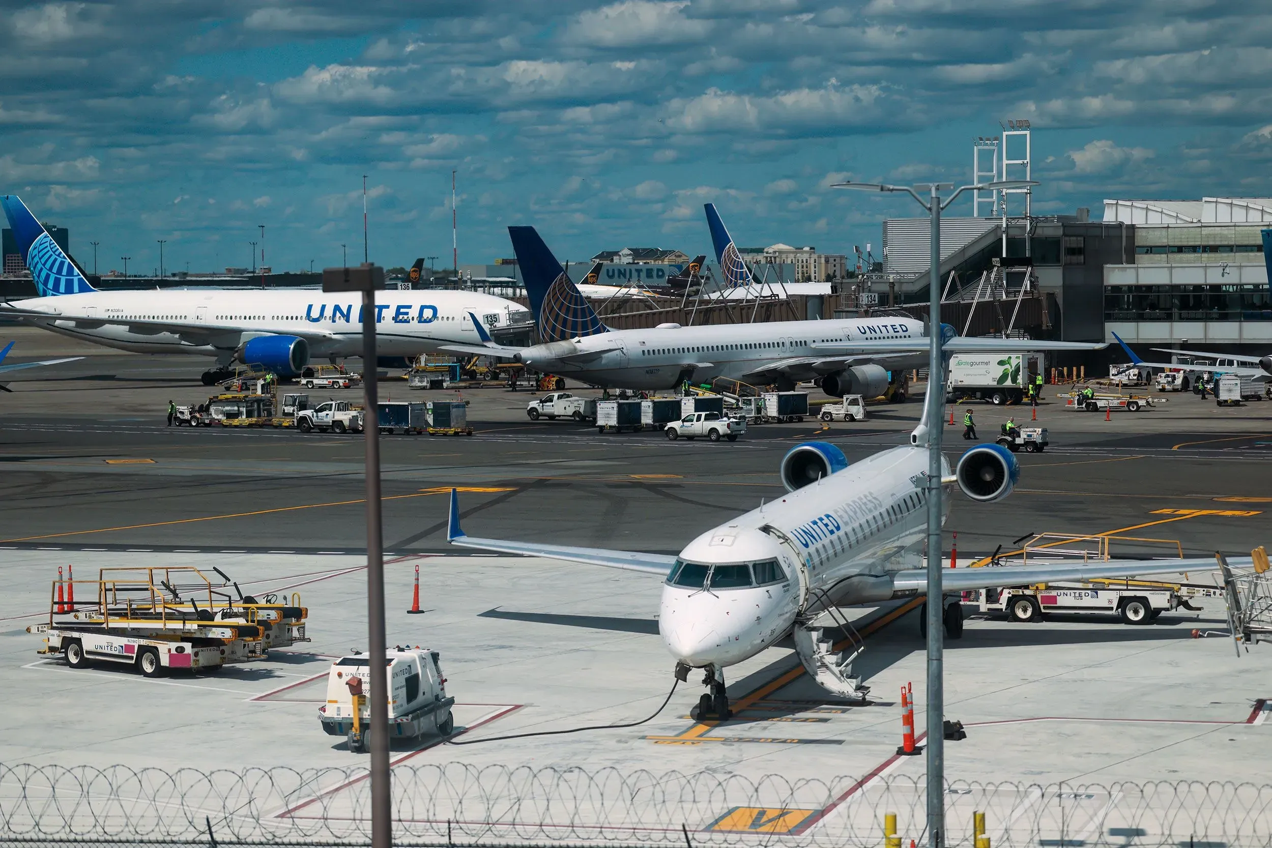 زيادة عدد الرحلات الجوية في مطار نيوارك ليبرتي الدولي، مع تواجد طائرات يونايتد والمعدات الأرضية في الخلفية.