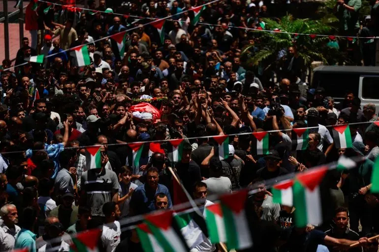 تجمع حشود كبيرة في جنازة سيف الله مسلط، مع رفع الأعلام الفلسطينية، تعبيرًا عن الحزن والغضب بعد مقتله على يد مستوطنين في الضفة الغربية.