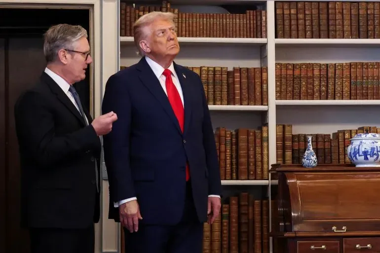 تظهر الصورة الرئيس الأمريكي السابق دونالد ترامب أثناء حديثه مع مسؤول في مكتب يتضمن رفوفاً مليئة بالكتب، مما يعكس أجواء البنتاغون.