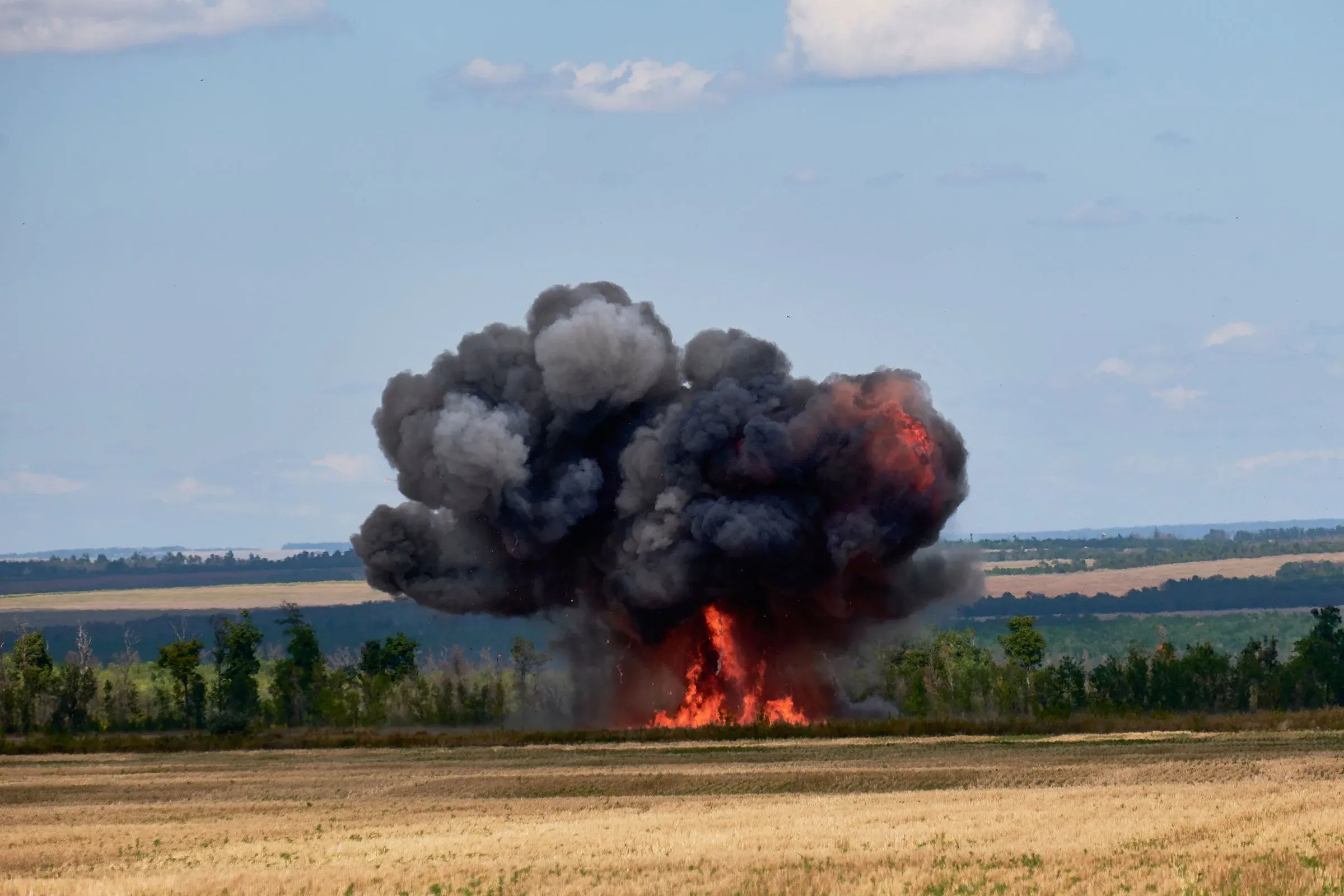 انفجار كبير يتصاعد من الأرض في ساحة المعركة، مع دخان أسود كثيف ونيران مشتعلة، يعكس تأثير الطائرات بدون طيار في النزاع.