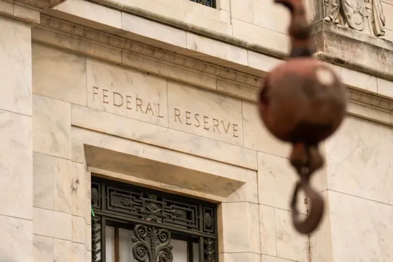 واجهة مبنى الاحتياطي الفيدرالي الأمريكي، مع التركيز على النقش "FEDERAL RESERVE"، تعكس التغيرات في السياسة النقدية وتأثيرها على الاقتصاد.
