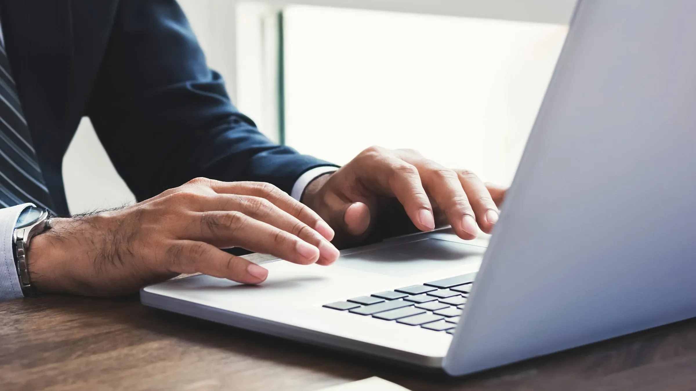 يد اللهت يمين على لوحة مفاتيح كمبيوتر محمول، مشيرًا إلى التوجهات الجديدة للوكالات الحكومية الأمريكية حول ضمائر الجنس.