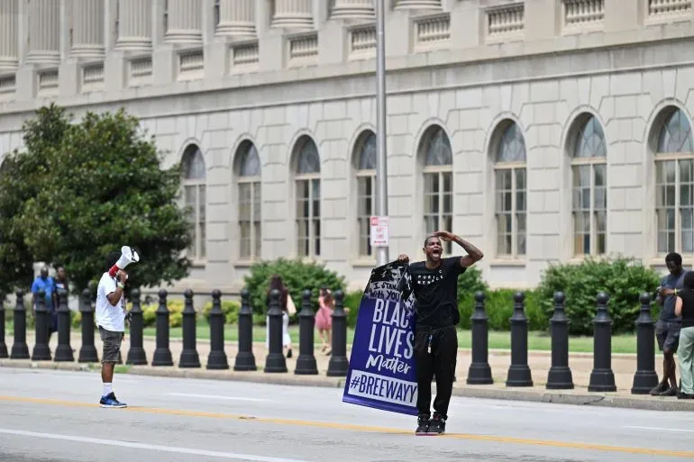 محتجون يحملون لافتة "حياة السود مهمة" أمام مبنى حكومي، تعبيرًا عن المطالبة بالعدالة بعد مقتل بريونا تايلور.