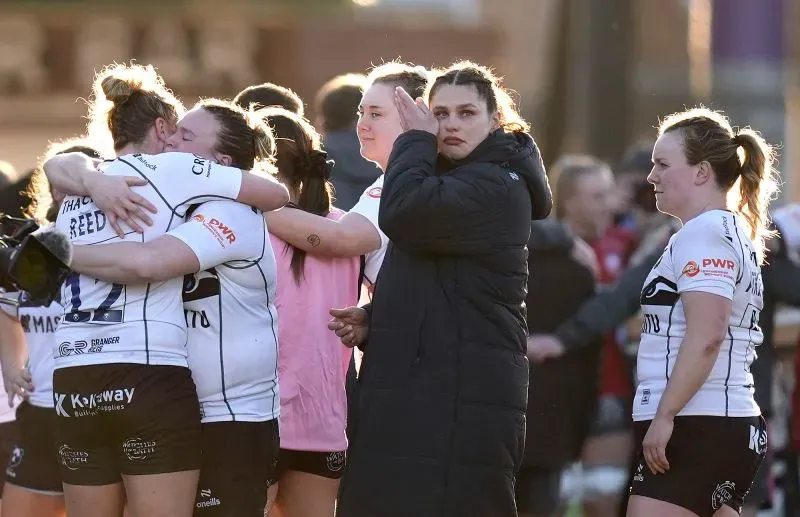 إيلونا ماهر تتأثر بعد مباراتها الأخيرة مع فريق بريستول بيرز، حيث تحتضن زميلاتها وتظهر مشاعر الحزن بعد الهزيمة.