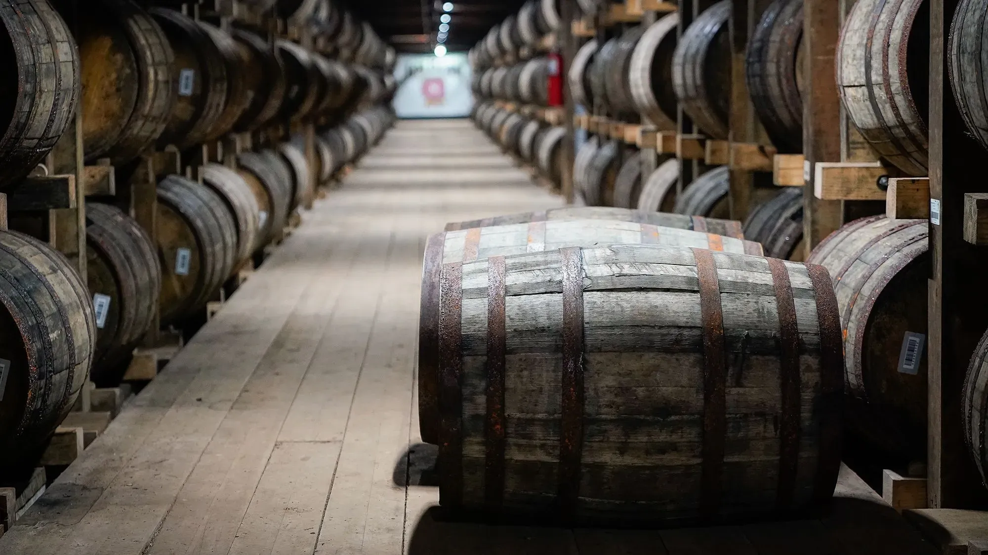 براميل خشبية مرتبة في مستودع لتخزين المشروبات الروحية، تعكس نمو صادرات المشروبات الأمريكية في ظل التحديات التجارية الحالية.