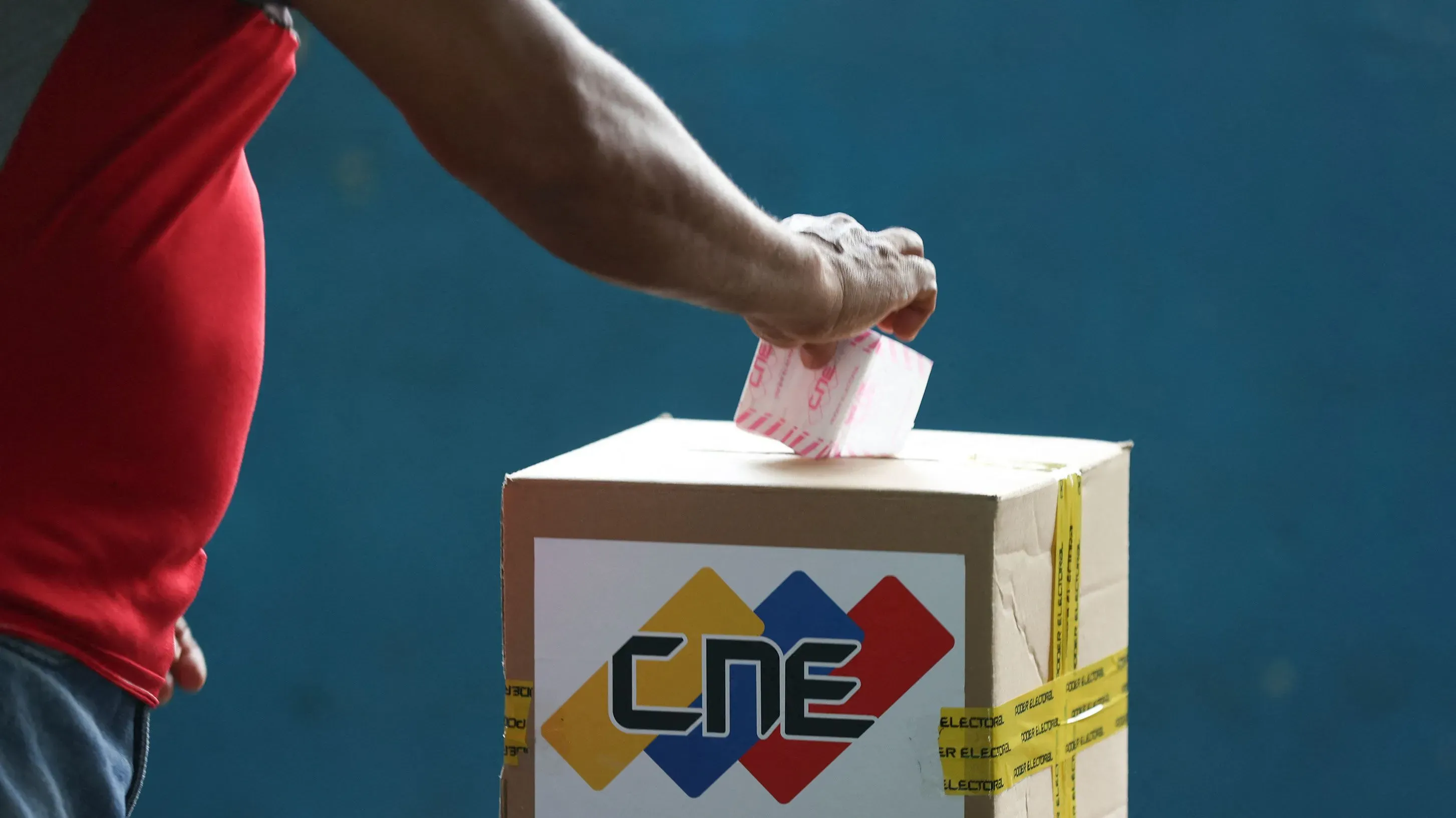 ناخب فنزويلي يضع صوته في صندوق الاقتراع خلال الانتخابات في منطقة إيسيكويبو، وسط توترات سياسية بشأن الإقليم الغني بالنفط.