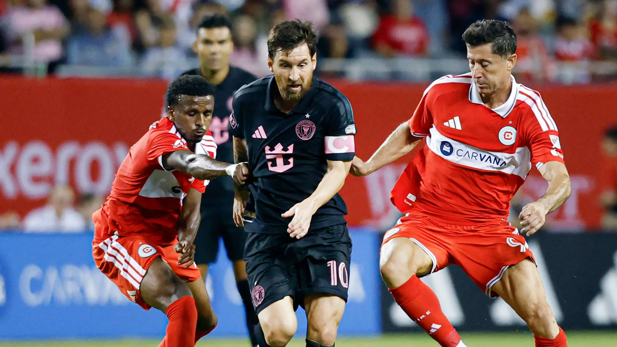 ليونيل ميسي يتقدم بالكرة بين لاعبي شيكاغو فاير خلال مباراة دوري MLS الأمريكية بحضور جمهور قياسي.