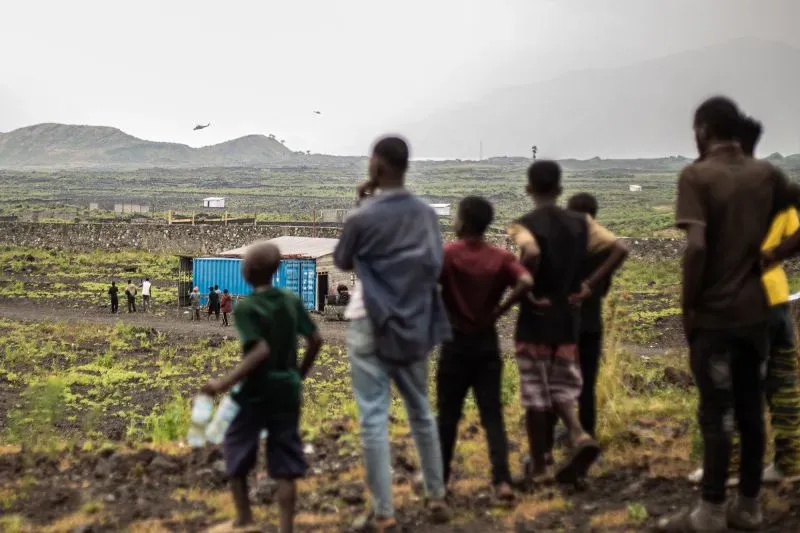 مجموعة من الأشخاص يشاهدون طائرة هليكوبتر فوق منطقة غوما، حيث يسيطر المتمردون على المدينة الغنية بالمعادن شرق الكونغو.